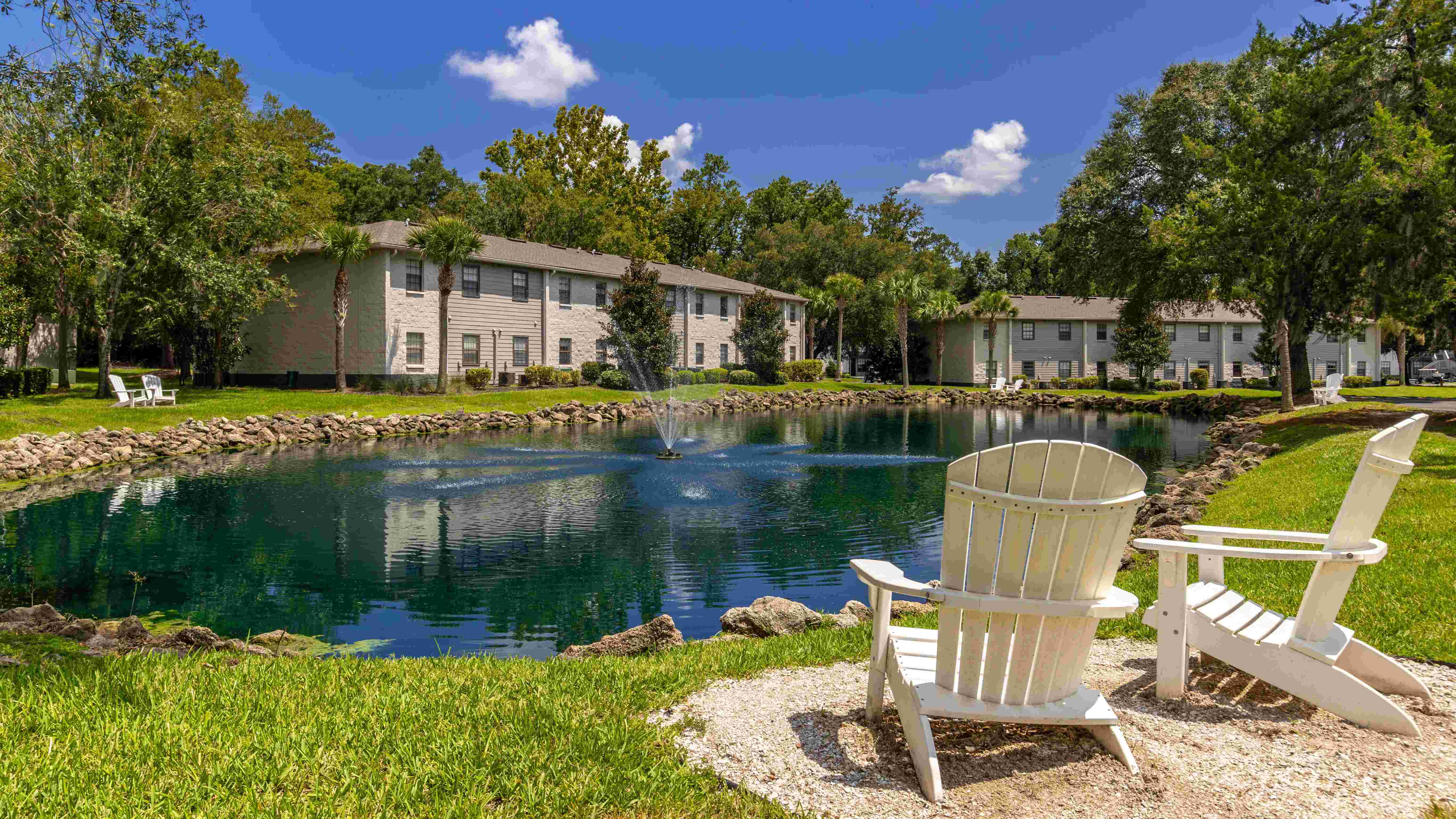 Discover a charming outdoor space with Adirondack chairs for a scenic view of the pond. 
