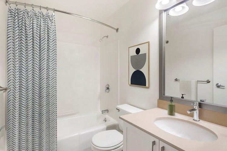 Renovated Package I bath with quartz or granite countertops, white cabinetry, and hard surface flooring
