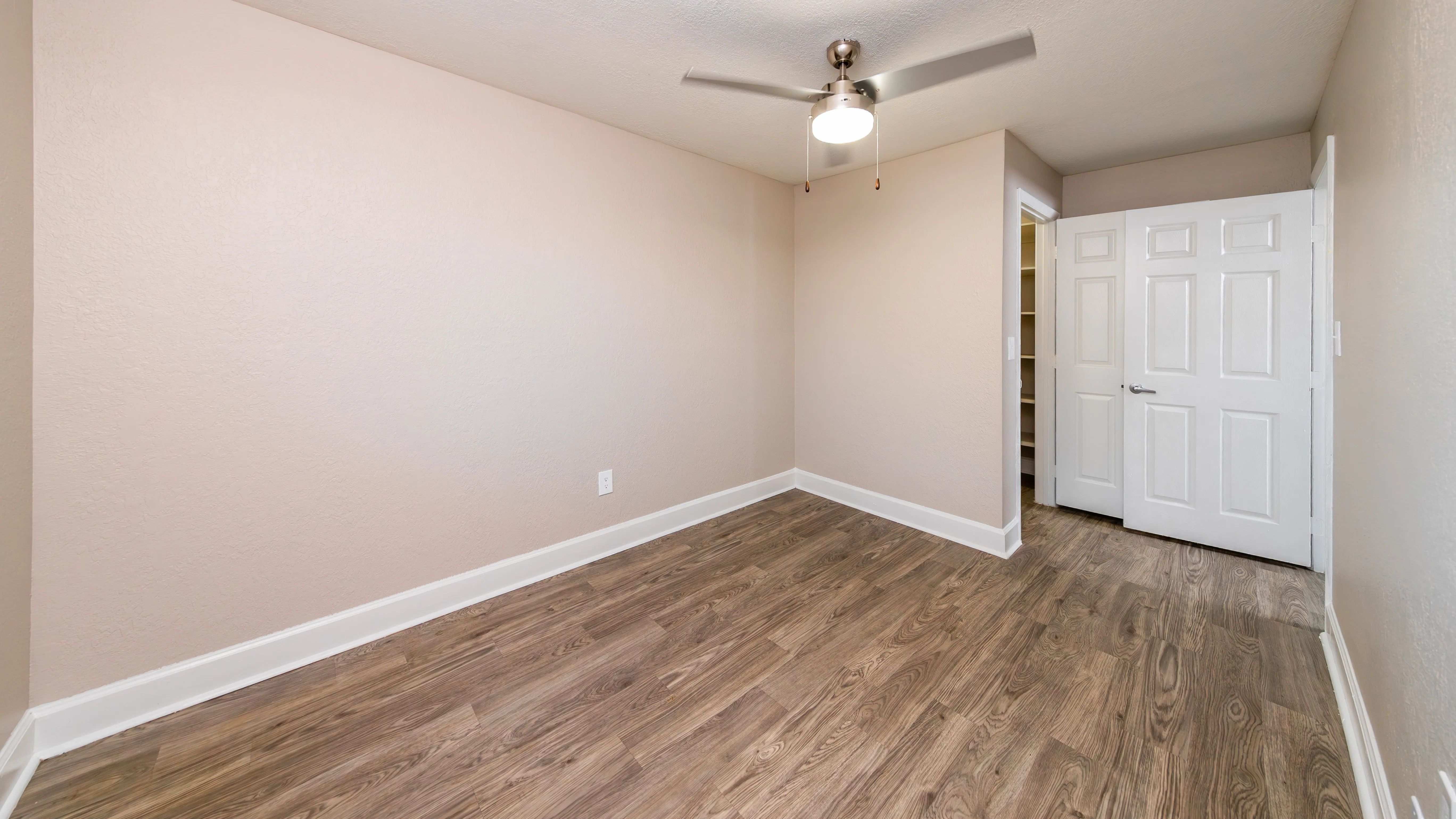 Find your peace in a spacious bedroom adorned with slick wood-style flooring. 