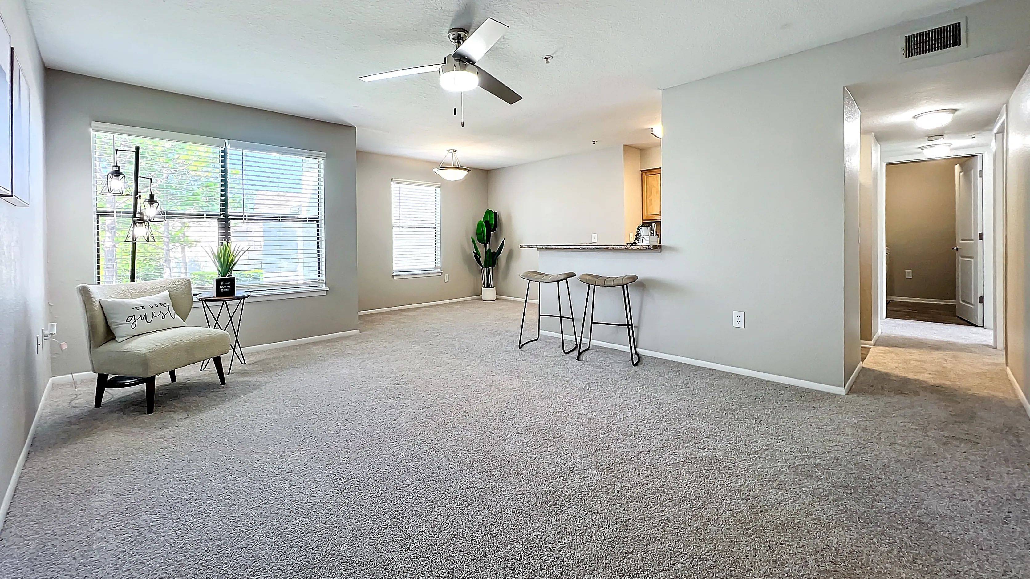 Discover the spacious and inviting living room featuring large windows, modern lighting, and an open layout perfect for relaxation and entertainment.