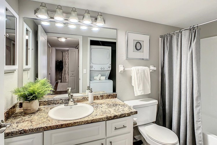 Designer bathroom with new granite style counter tops and modern vanity with exceptional storage space.