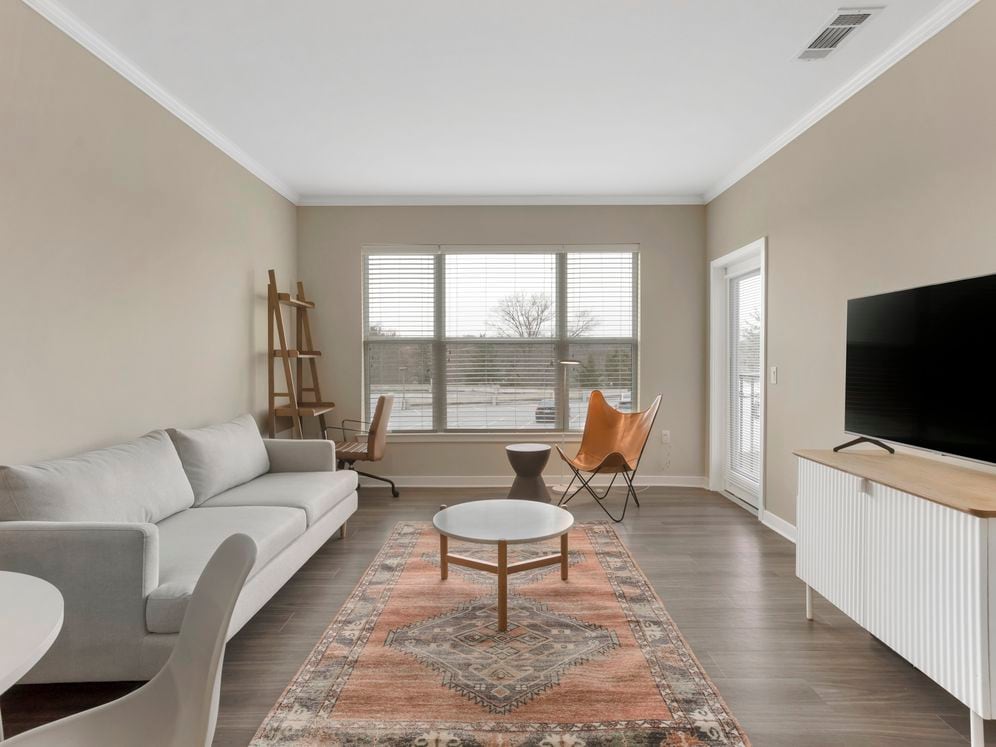 Furnished+ apartment homes come outfitted with a sofa, side chair, side table, coffee table, TV stand and 50" Television (Representative Image – exact items and style of furnishings may vary)