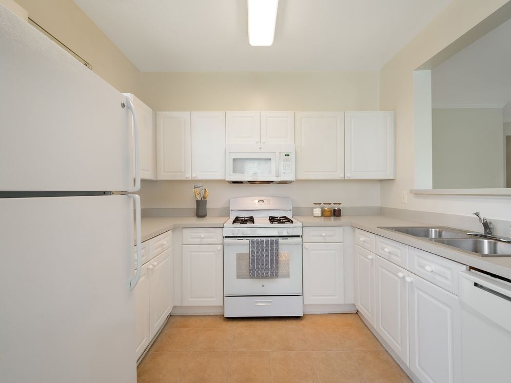 Classic Package I kitchen with white cabinetry, beige laminate countertops, white appliances, and hard surface flooring