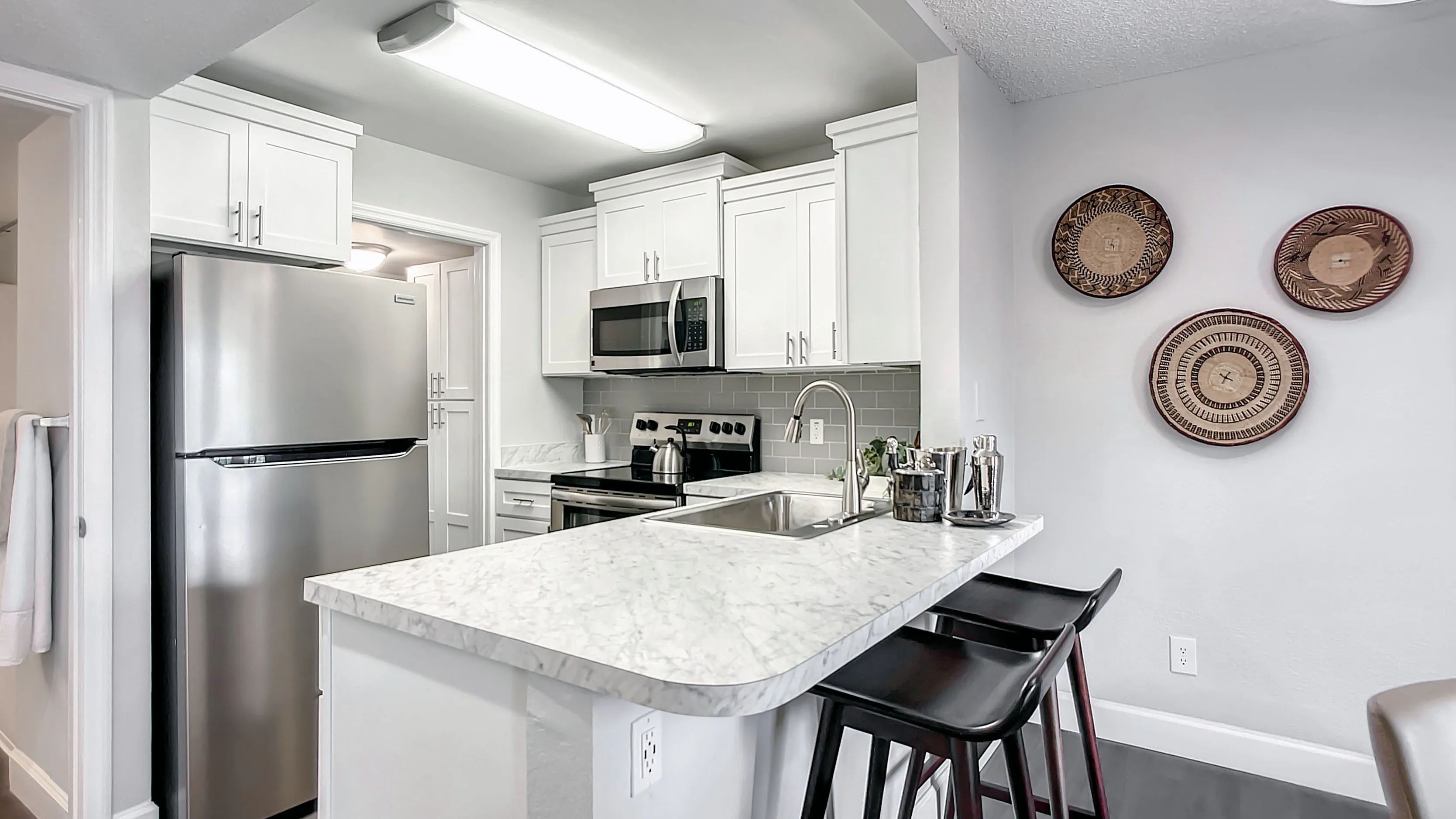 Elevate your cooking experience in our renovated gourmet kitchens with stunning white marble-inspired countertops and a breakfast bar.