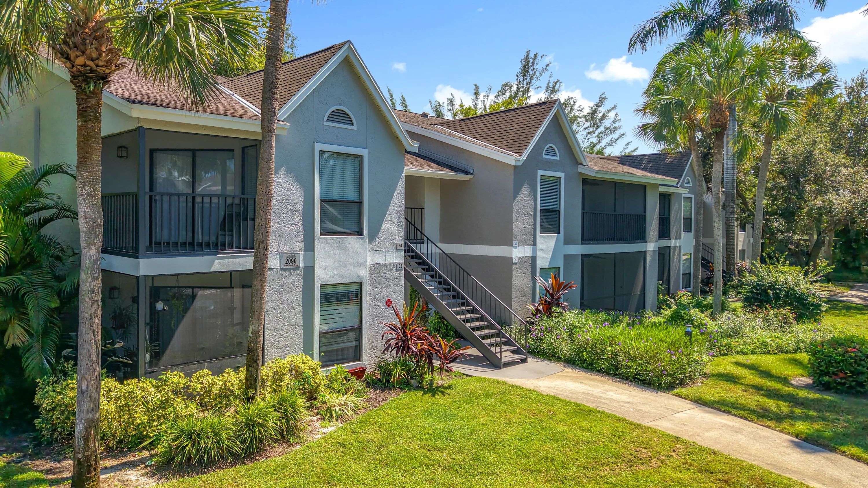 Enjoy morning coffee or evening breezes from your private screened-in patio, surrounded by tropical landscaping and serene green spaces.