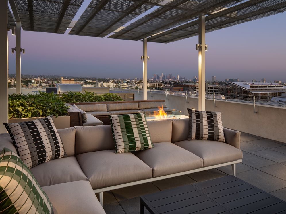 Roofdeck at dusk with outdoor fireplace, lounge seating and panoramic views