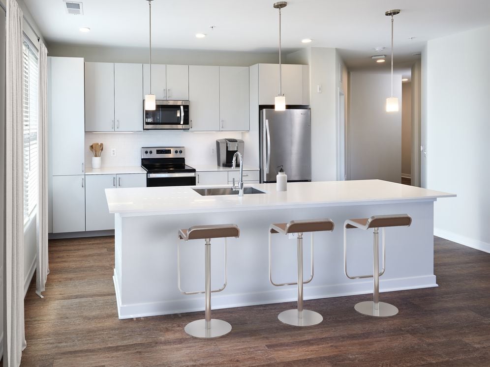 Design Collection I Kitchen with light grey cabinetry, white quartz countertops, pendant lighting, and hard surface flooring