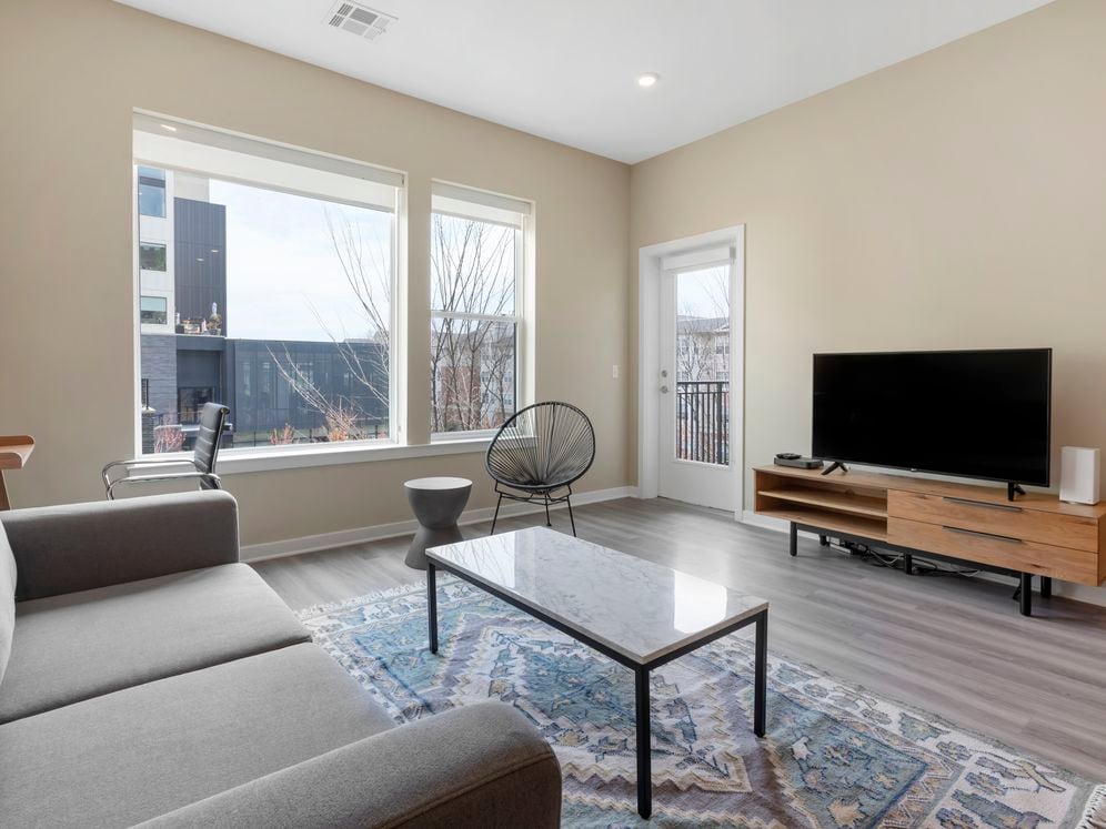 Furnished+ apartment homes come outfitted with a sofa, side chair, side table, coffee table, office chair, desk, TV stand and 50" Television (Representative Image – exact items and style of furnishings may vary)