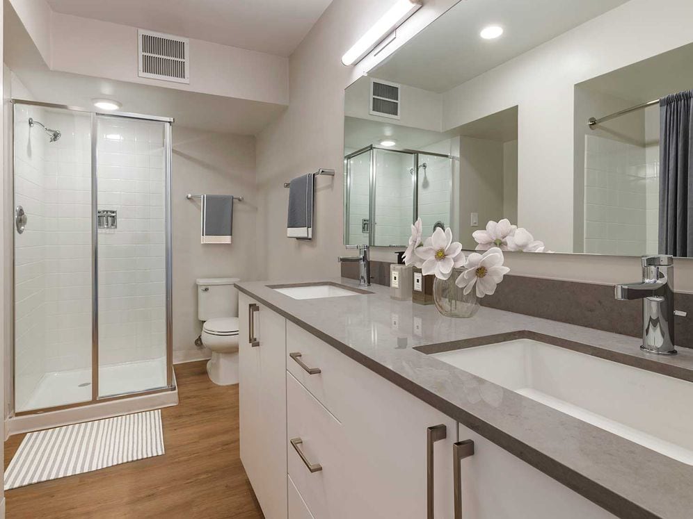 Limited availability: newly renovated Finish Package II apartment homes featuring baths with grey quartz countertops, white cabinetry, and hard surface flooring