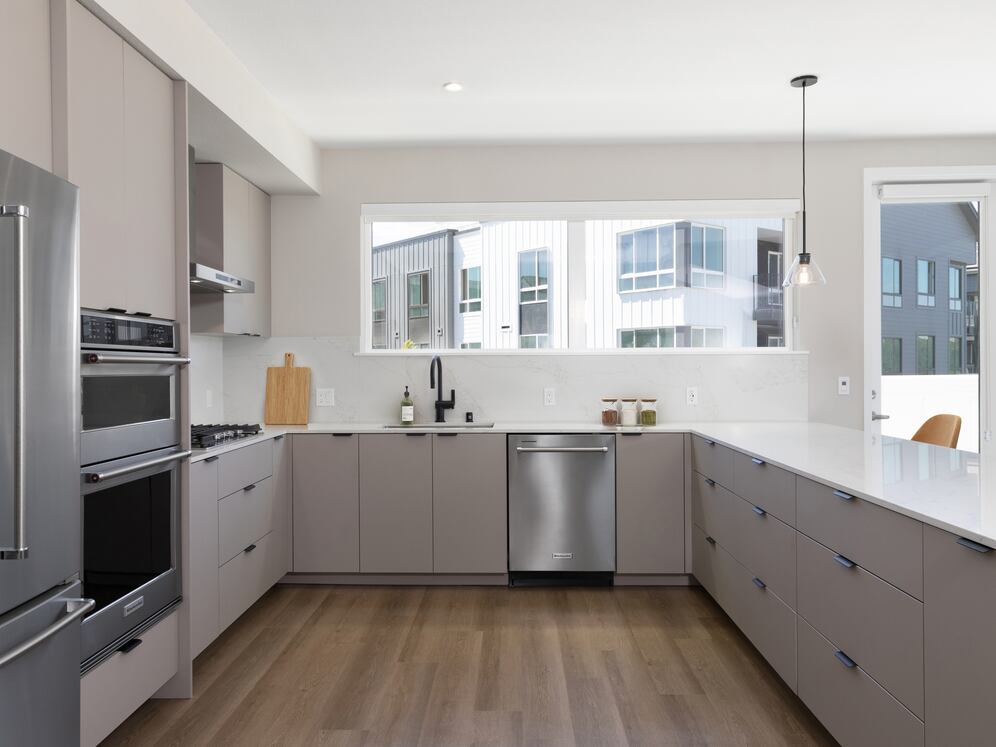 Signature Collection I 4-Bedroom Townhome Kitchen with light grey cabinetry, white marbled quartz countertop, and upgraded stainless steel appliances