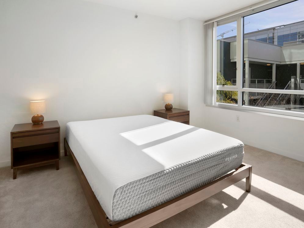 Furnished+ apartment homes feature queen bed with mattress, dresser, nightstands, and lamps (Representative Image – exact items and style of furnishings may vary)