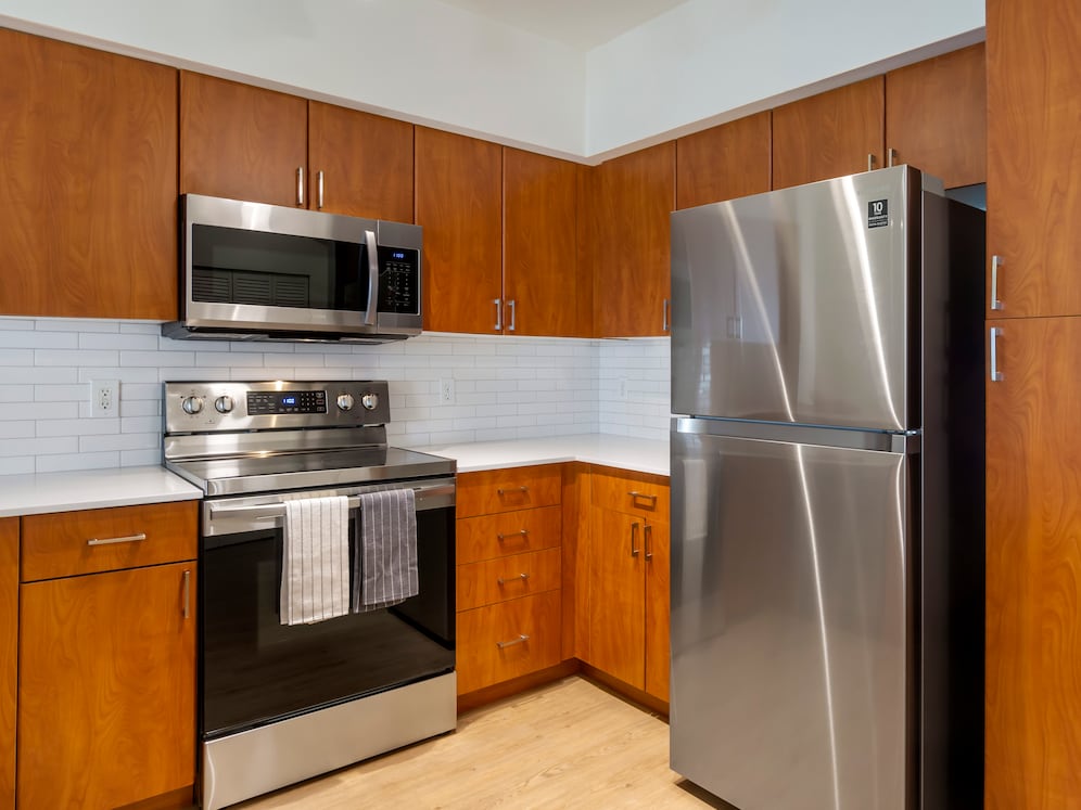 Renovated Package I kitchen with cherry cabinetry, white quartz countertops, stainless steel appliances, upgraded lightning, and hard surface flooring