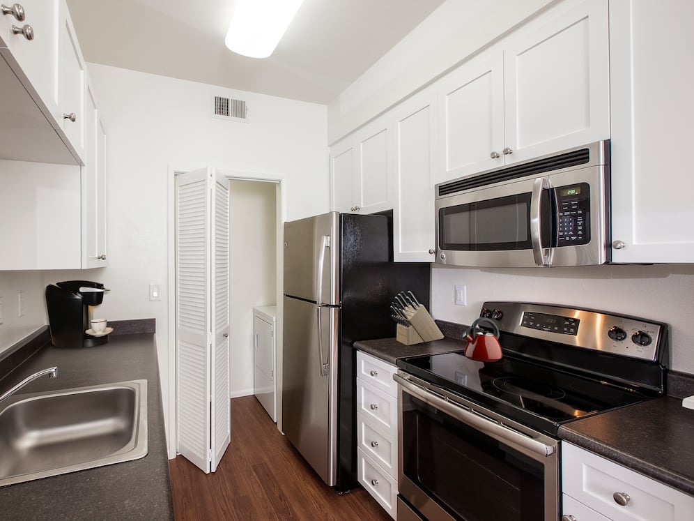 Classic Package I kitchen with stainless steel appliances, white cabinetry, laminate countertops, and hard surface flooring