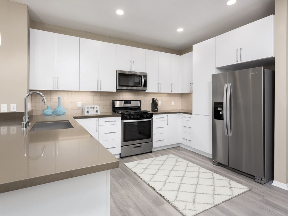 Newly renovated Design Scheme I kitchen with new cabinets, quartz countertops, stainless steel appliances, and hard surface plank flooring