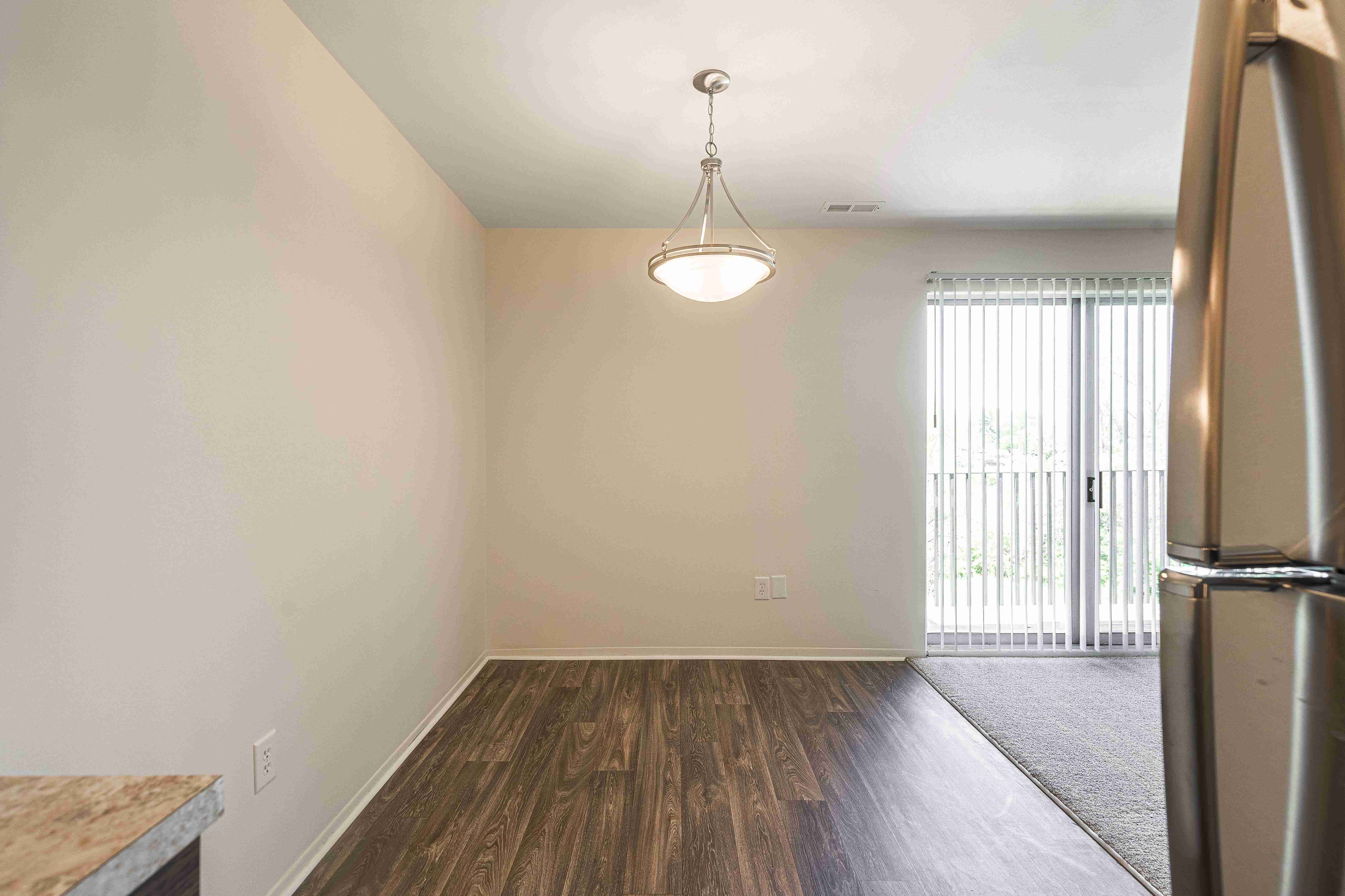 Spacious dining room with natural light and hardwood floors at Knottingham Apartments in Clinton Township, MI