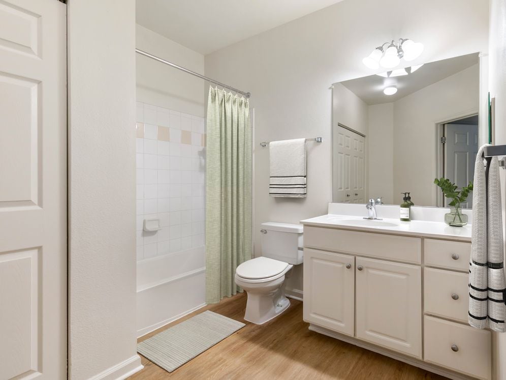 Classic I bath with white cabinetry, white laminate countertops, and hard surface flooring