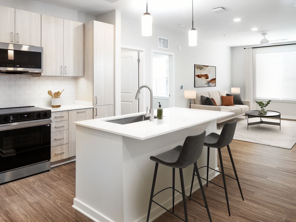 Upgrade Collection I kitchen with stainless steel appliances, white quartz countertops, white tile backsplash, light oak cabinetry, and hard surface flooring (representative imagery)