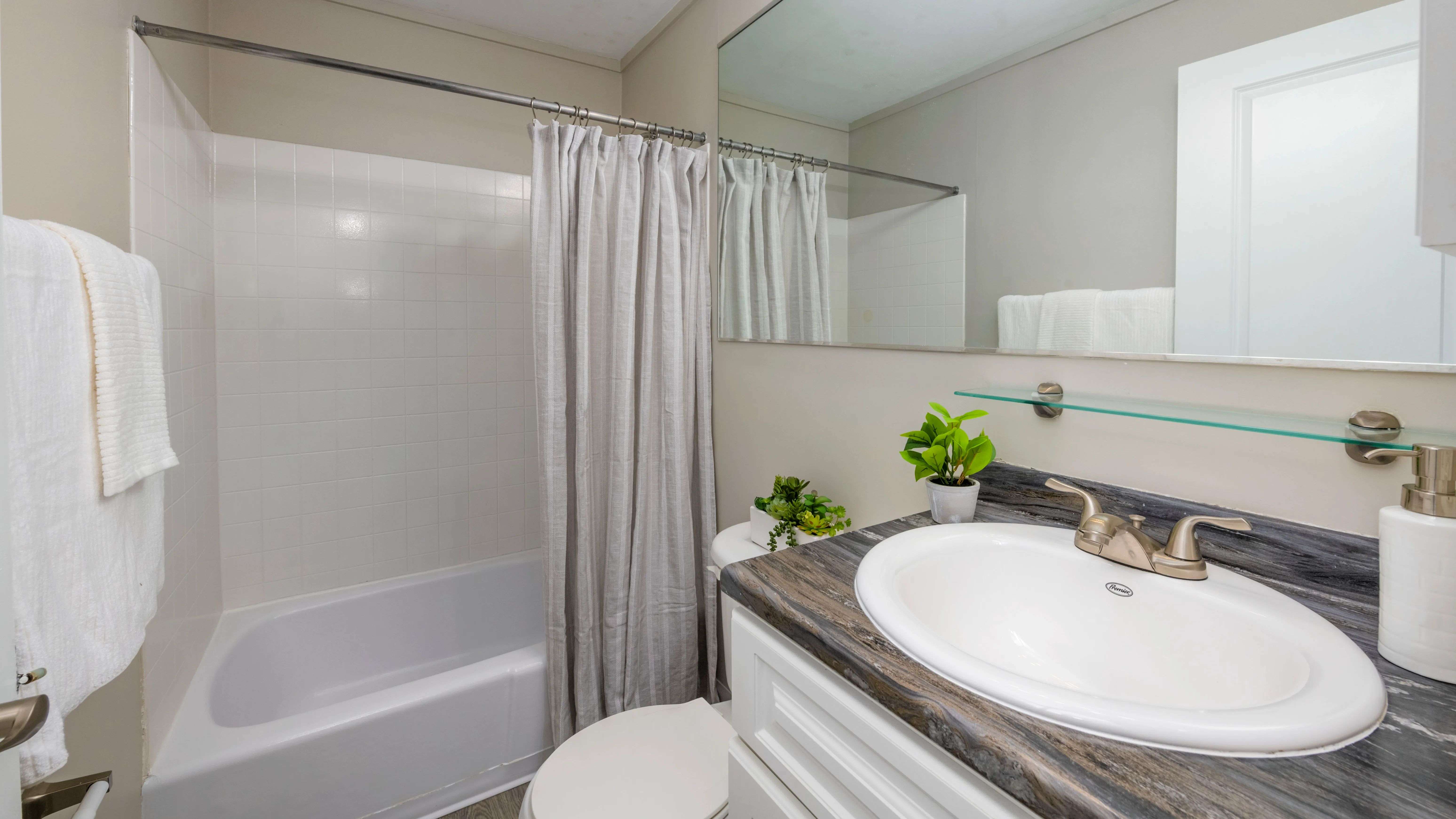 Discover the allure of our thoughtfully designed bathroom space – elevated by a generous mirror at Aspen Chase.