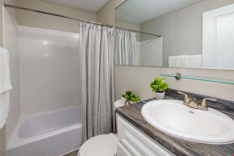 Discover the allure of our thoughtfully designed bathroom space – elevated by a generous mirror at Aspen Chase.