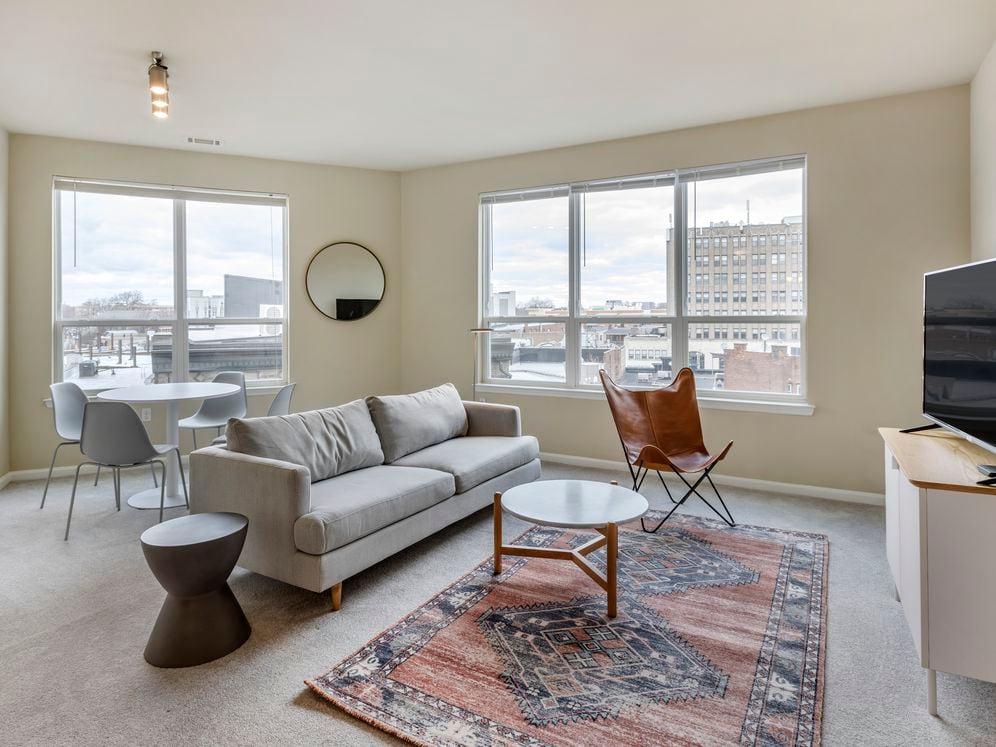 Furnished+ apartment homes come outfitted with a sofa, side chair, side table, coffee table, TV stand and 50" Television (Representative Image – exact items and style of furnishings may vary)