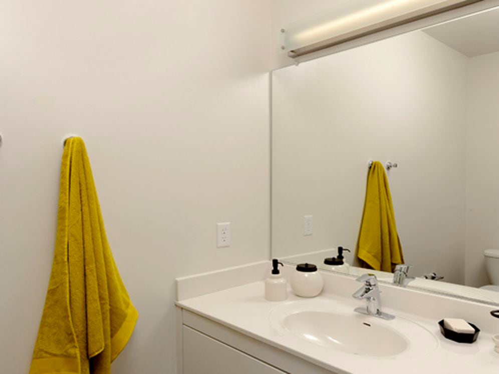 Urban bath with white cabinetry, white laminate countertops, and hard surface flooring