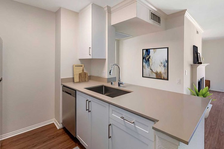 Renovated Package kitchen with stainless steel appliances, beige quartz countertops, new white cabinetry, and hard surface flooring