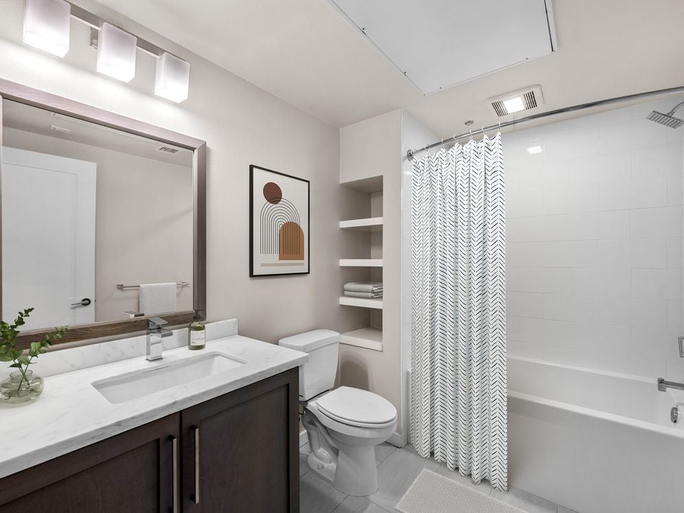 Baths with dark cabinetry, white quartz countertops, and hard surface flooring