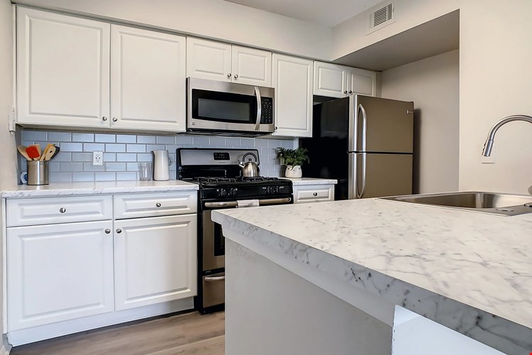 Swoon over our newly remodeled kitchen with its pristine white cabinets, gray subway tile backsplash, and white Carrara countertops, all complemented by stainless steel appliances.