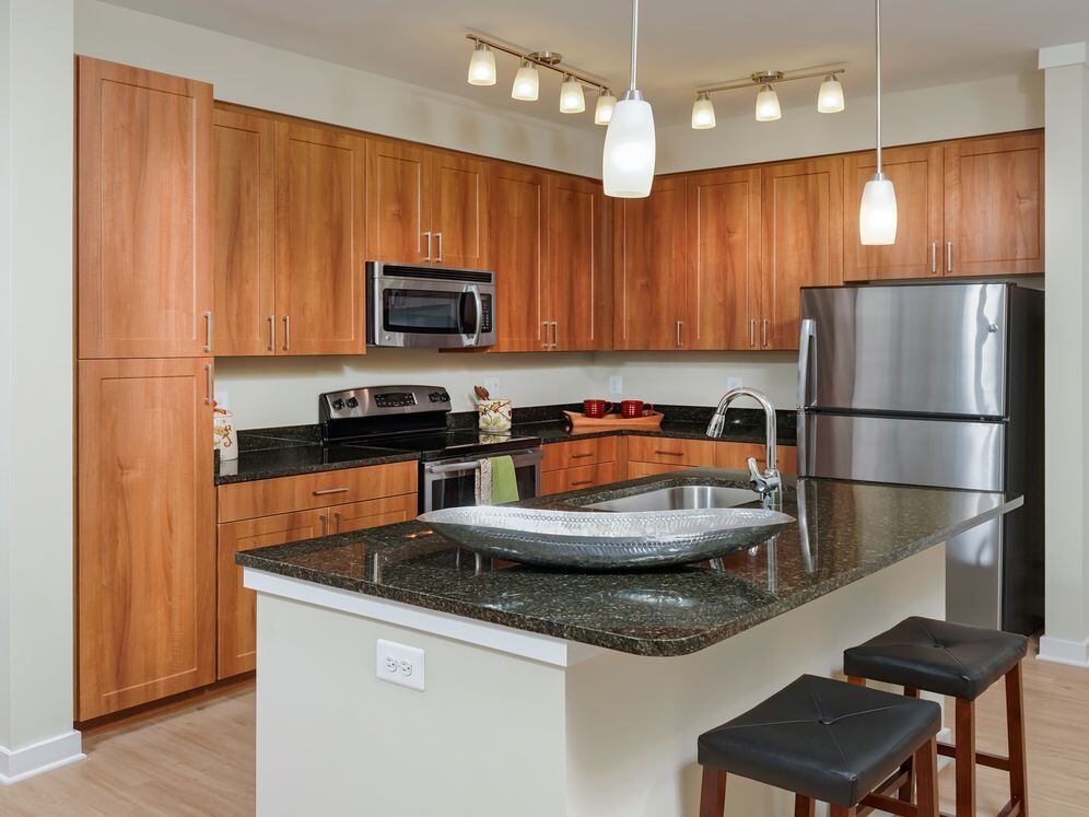 Open concept kitchen with granite countertops, stainless-steel appliances, kitchen island and hard surface flooring