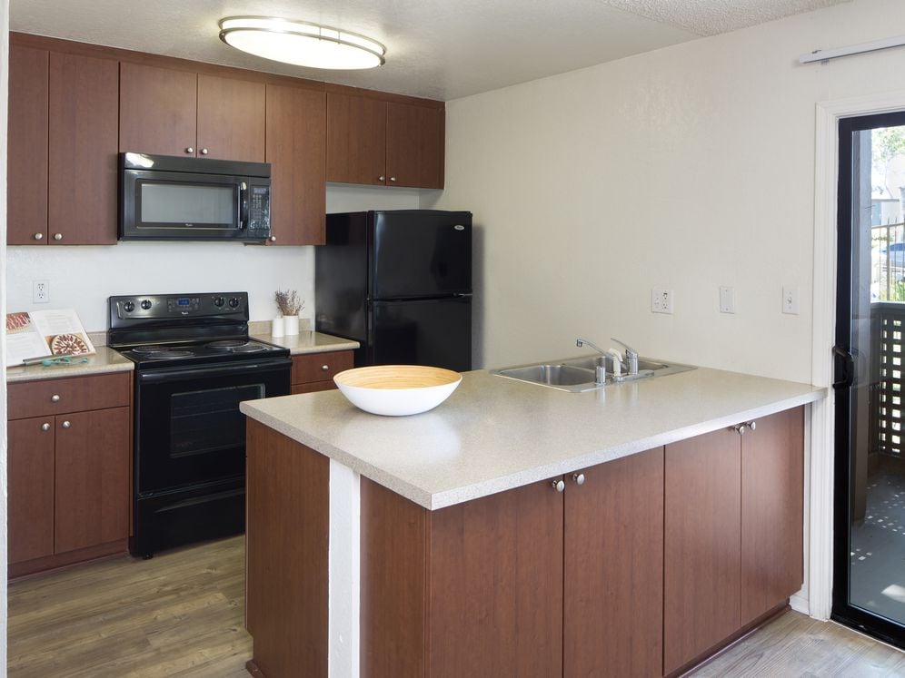 Kitchen with black appliances and hard surface vinyl plank flooring