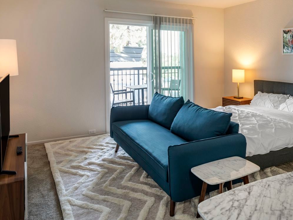 Furnished+ apartment homes come outfitted with a sofa, side chair, side table, coffee table, TV stand and 50" Television (Representative Image – exact items and style of furnishings may vary)