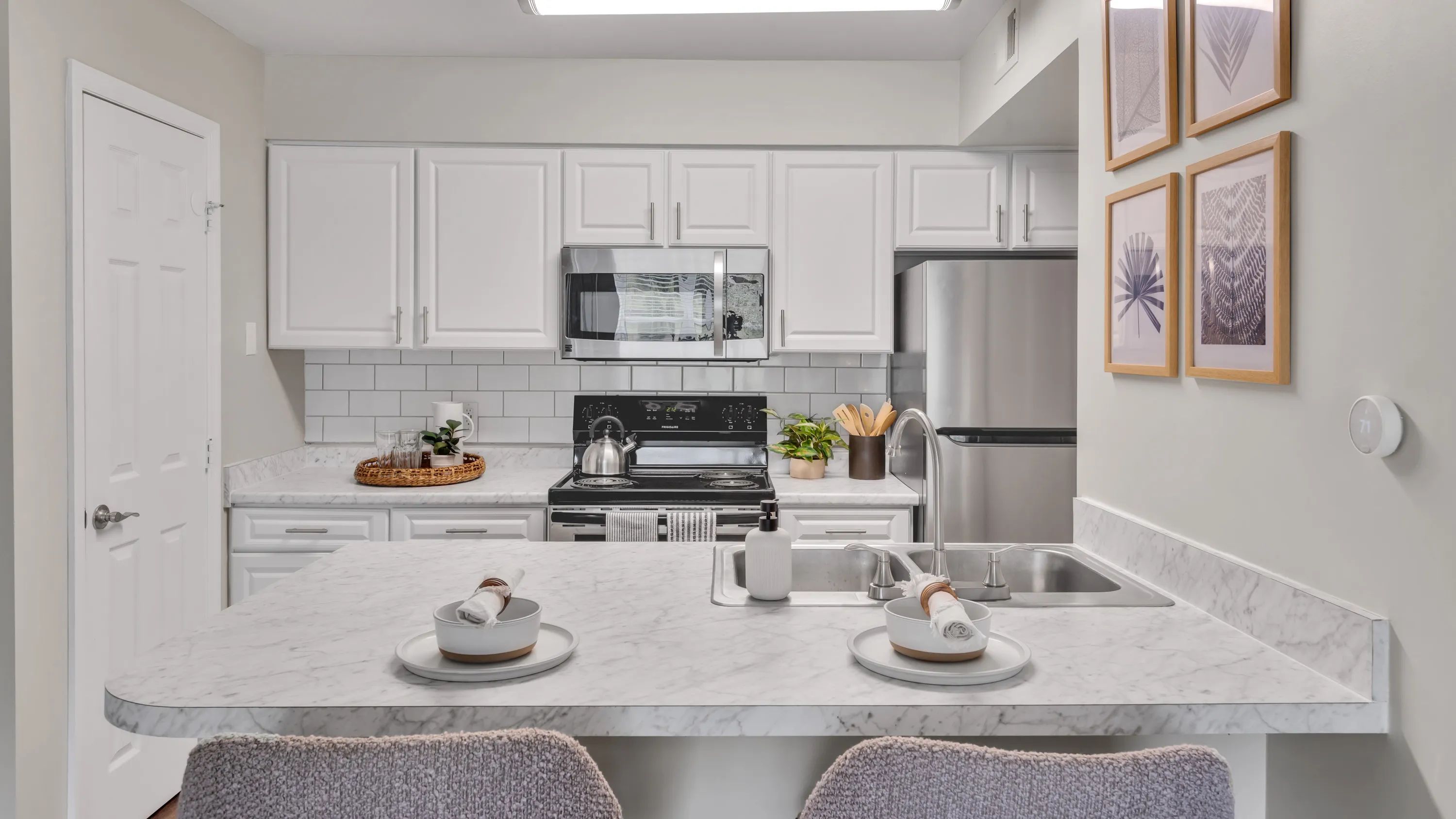 Experience elegance in our newly renovated kitchens with stunning white cabinetry, Carrara countertops, and a white subway tile backsplash, designed to inspire culinary enthusiasts. 