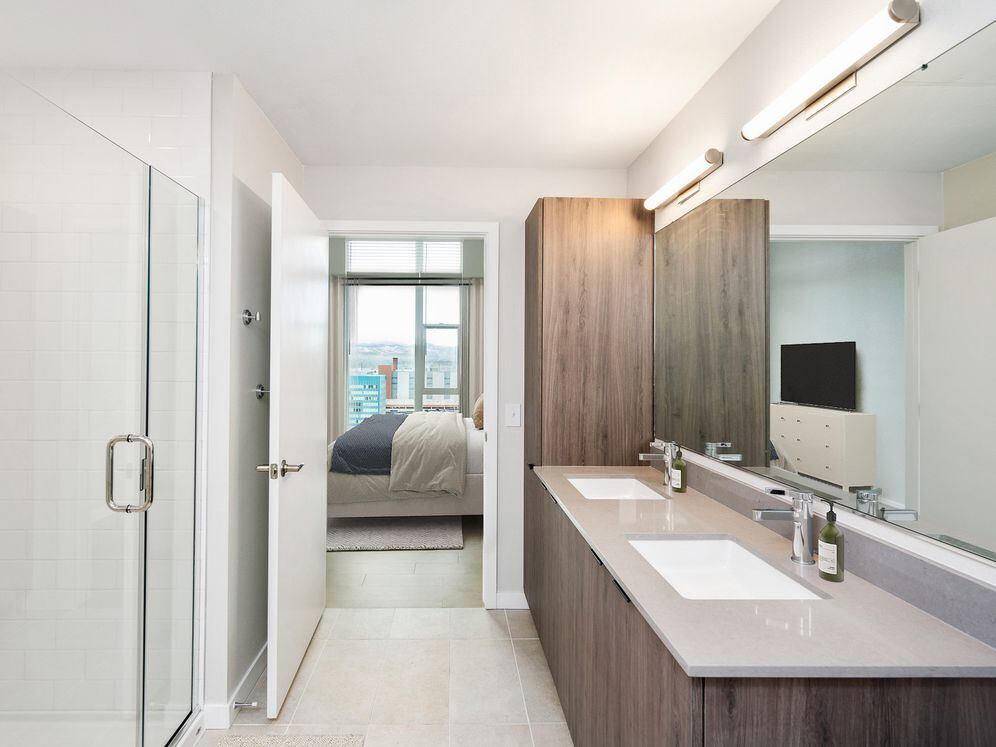 Signature Collection bath with marbled quartz countertop, double vanity, LED lighted vanity mirror, and tile flooring.