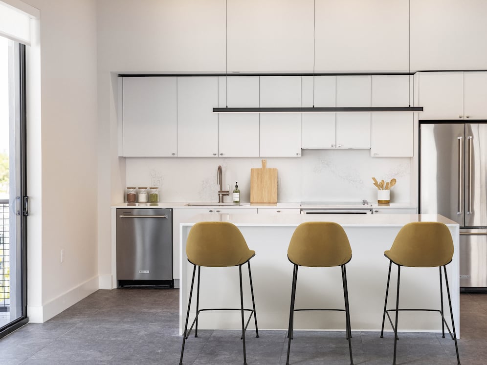 Signature Collection kitchen with white cabinetry, white marbled quartz countertop and backsplash, wine fridge, and upgraded stainless steel appliances