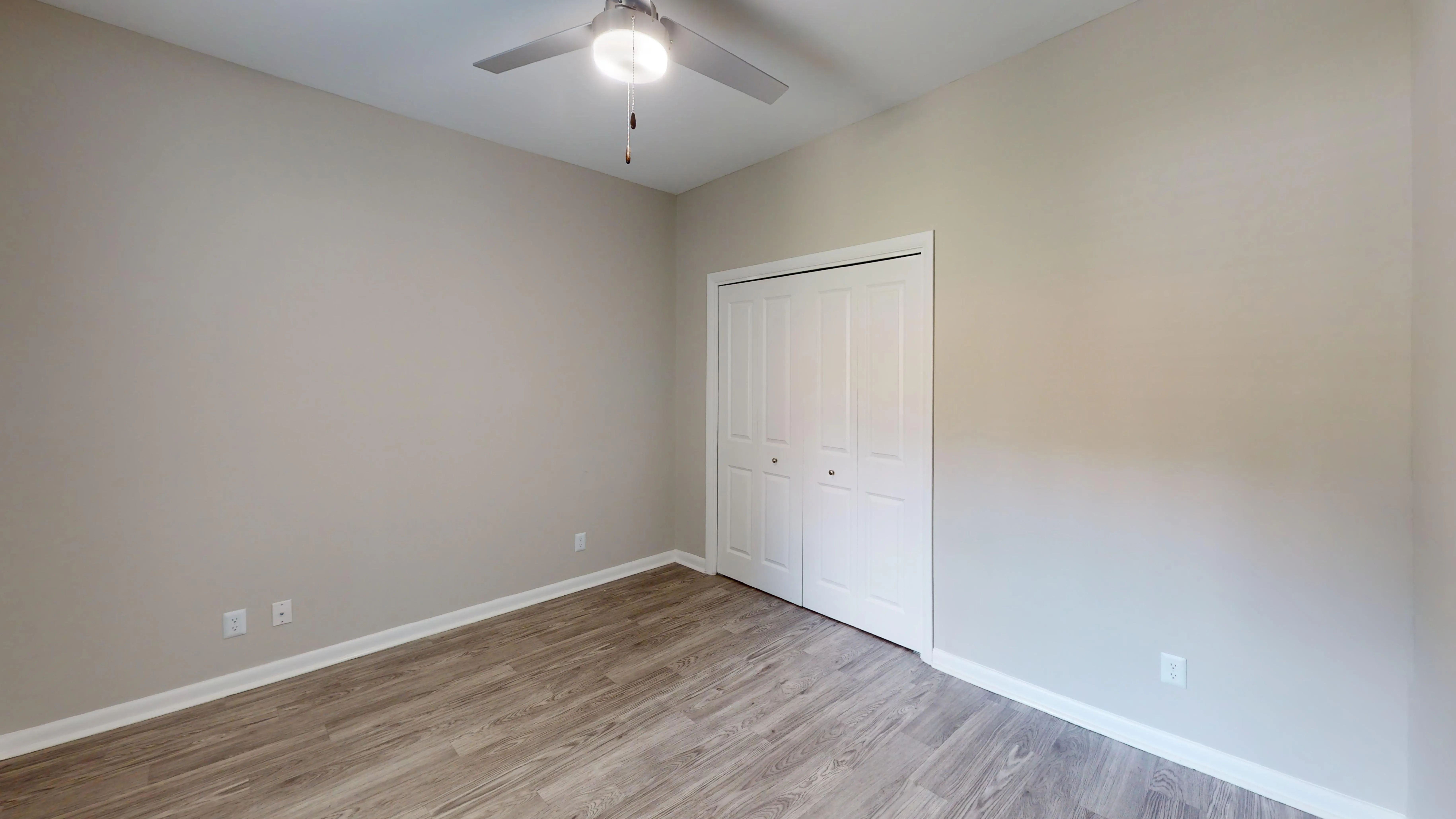 Offering a clean, contemporary aesthetic, this bedroom in The Rosewood floor plan provides a spacious layout, stylish wood-style flooring, and ample closet space.