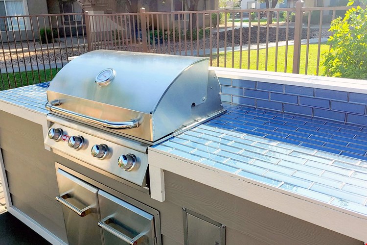 Our poolside outdoor grilling station boasts a ready-to-go, stainless steel gas grill and ample countertop space for the ultimate BBQ cookout extravaganza.
