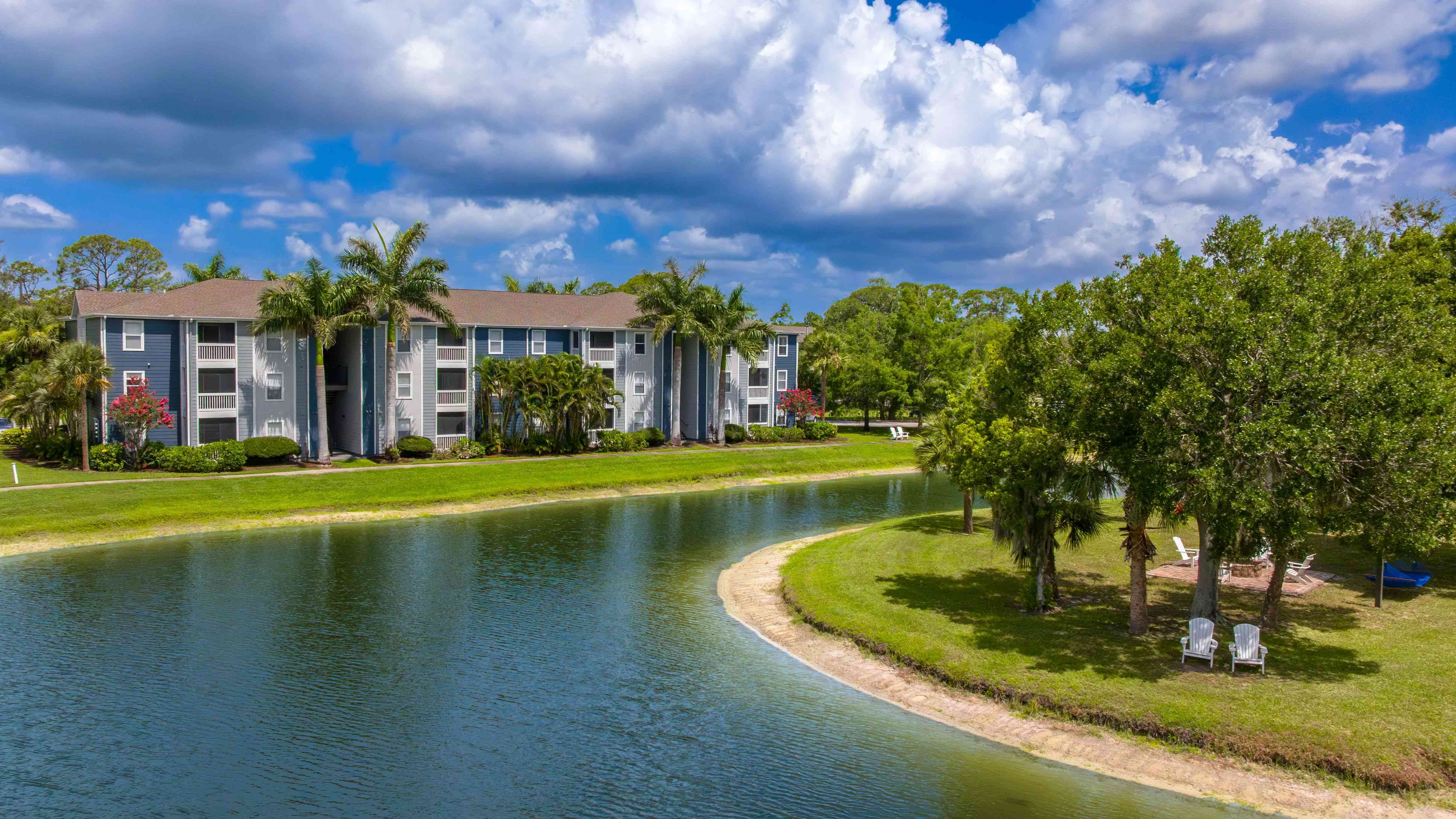 Experience the beauty of waterfront living at Grand Oaks with picturesque views, tropical landscaping, and inviting outdoor seating.