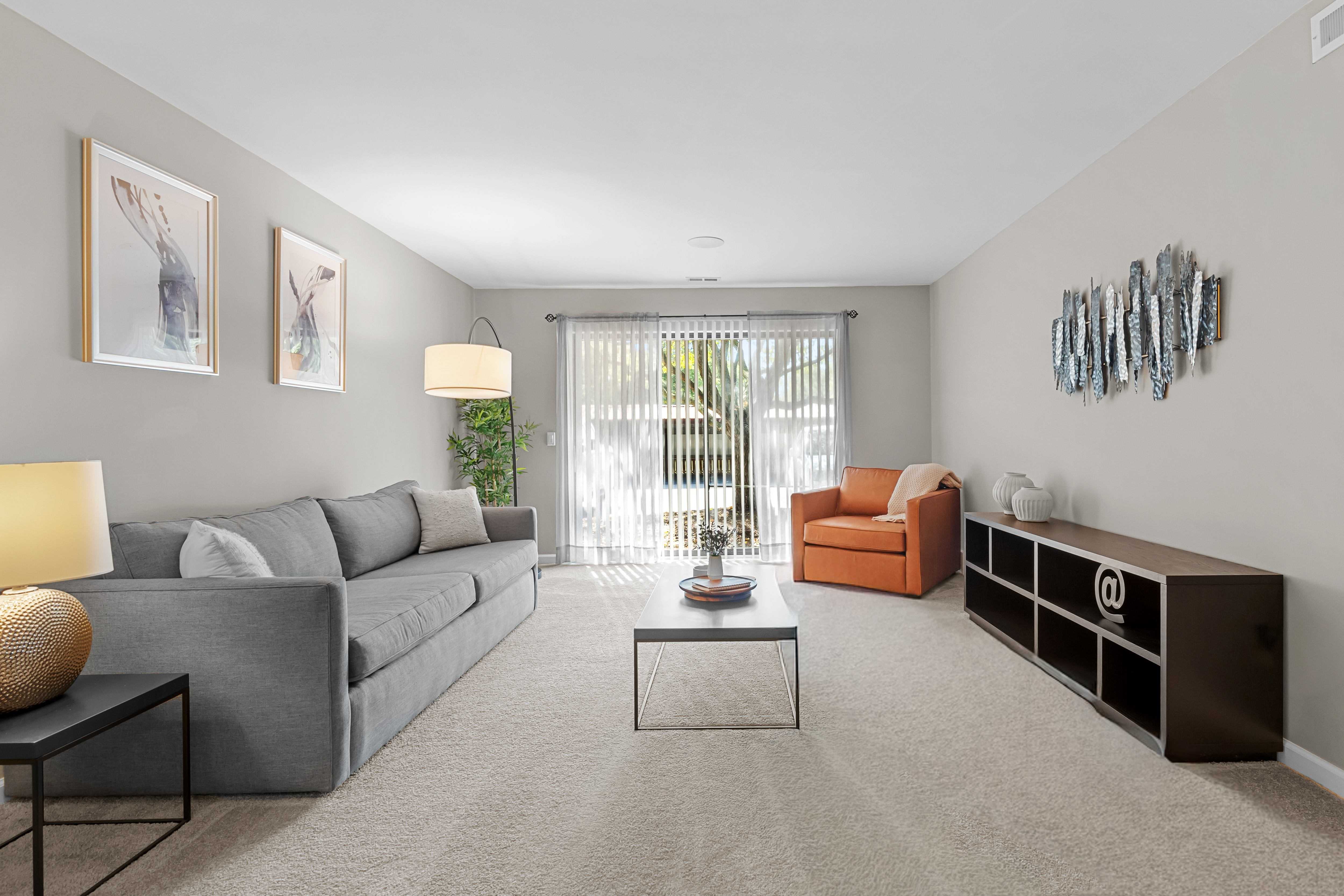 Spacious Living Room with Sliding Glass Door at Lakeside Village Apartments Clinton Township MI