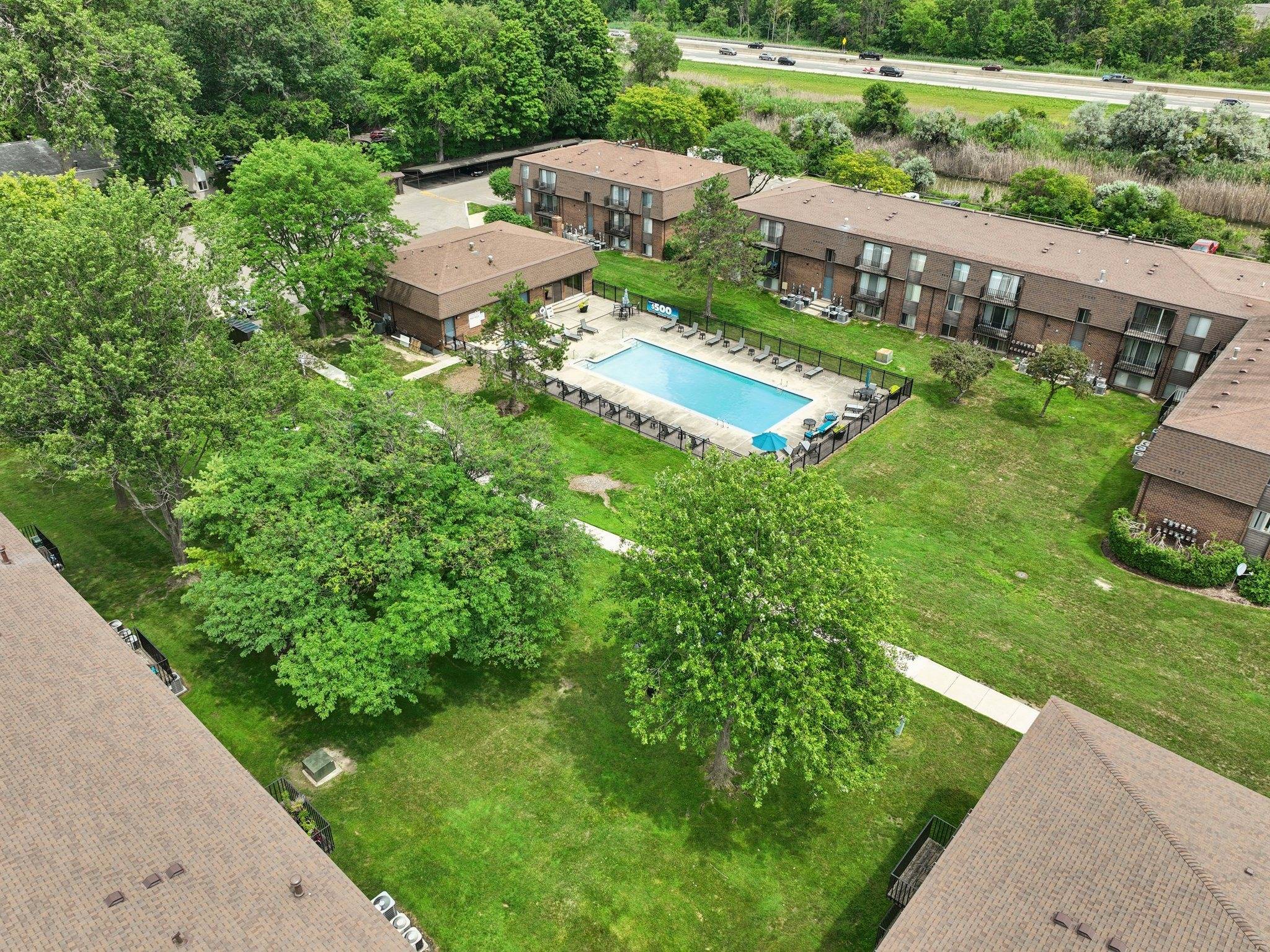 Expansive green space and heated pool at Drawbridge Apartments in Harrison Township, MI.