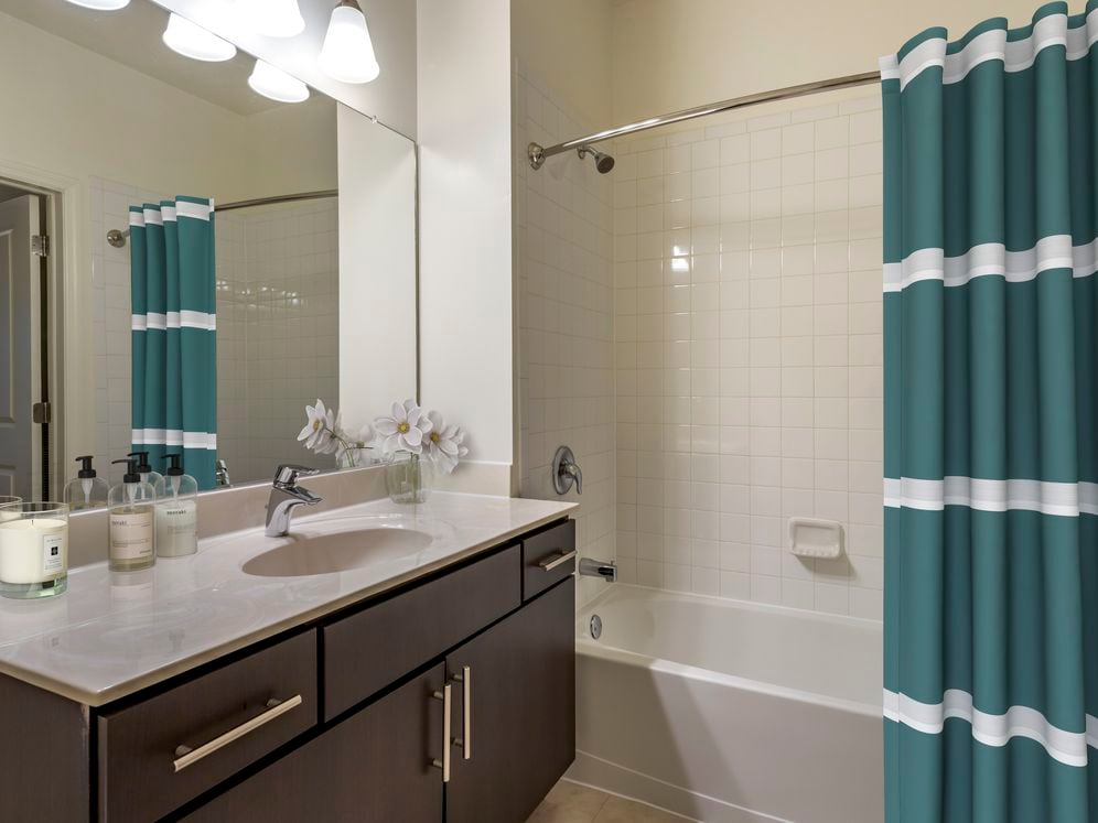 Newly renovated apartment homes feature baths with espresso cabinetry, grey quartz countertops, and hard surface flooring