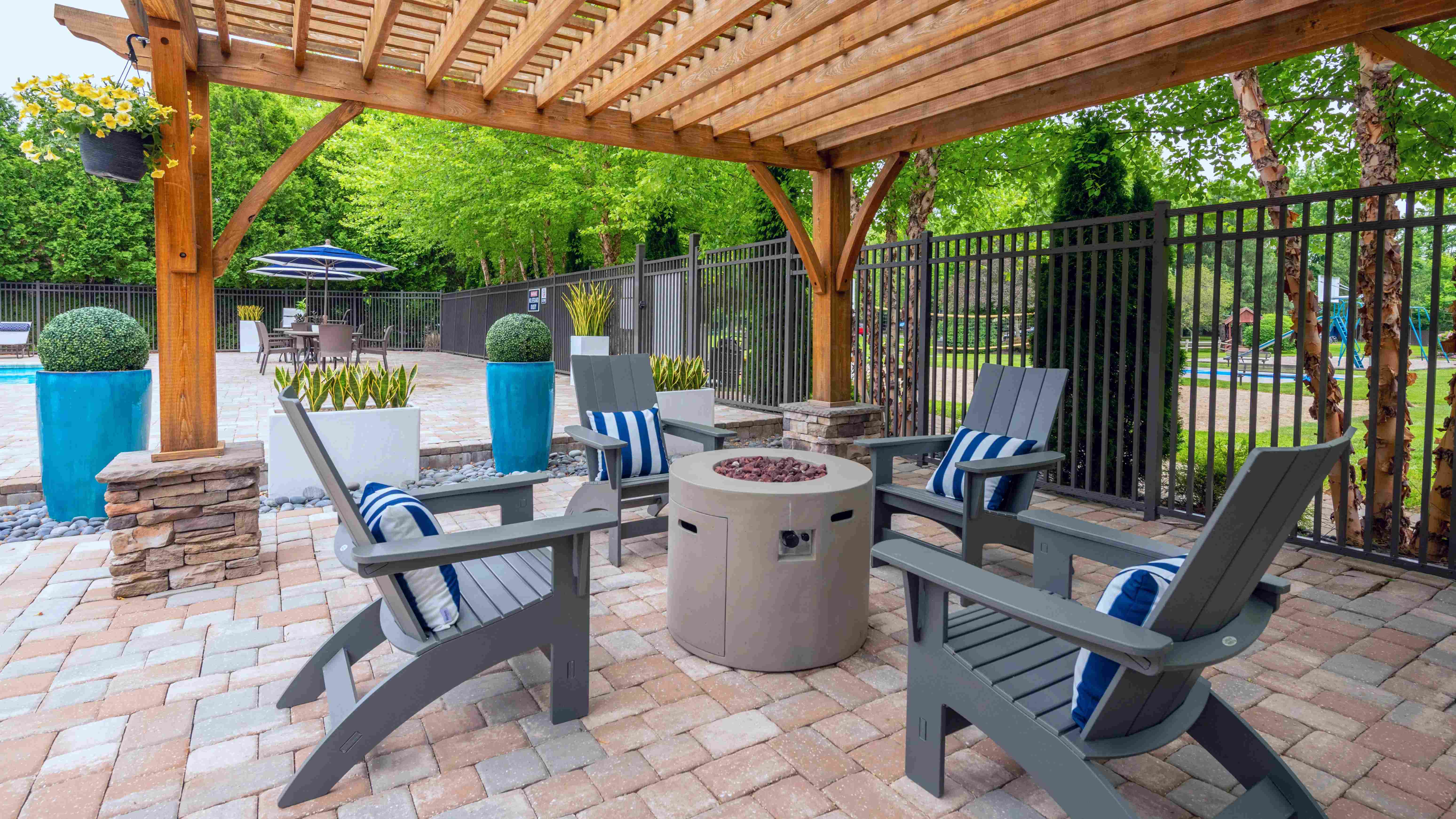 Cozy up by our firepit beneath a chic pergola, a perfect evening retreat by the pool. 