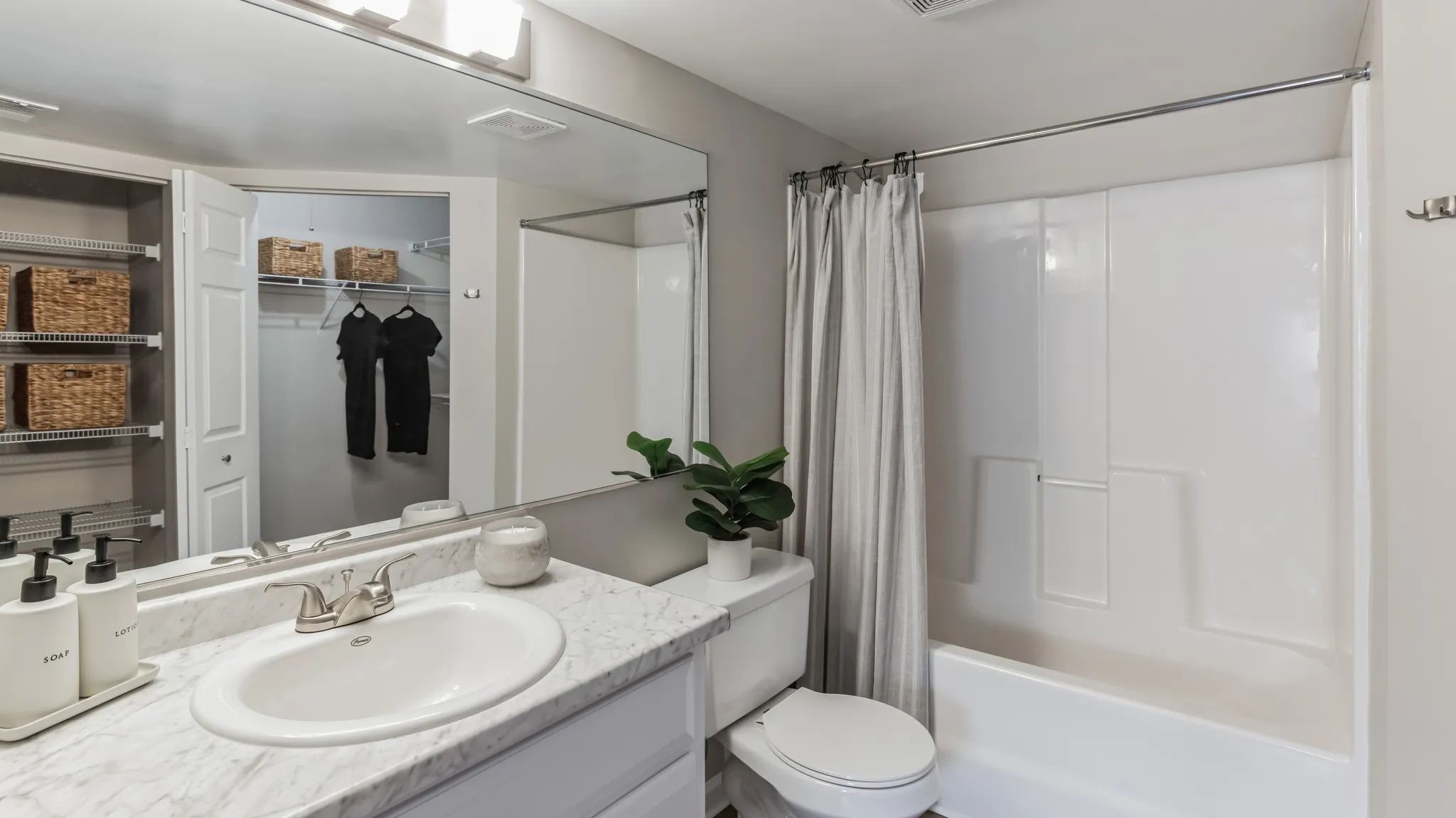 Revel in the luxurious primary bathroom oasis, featuring wood-style flooring and an oversized vanity. 