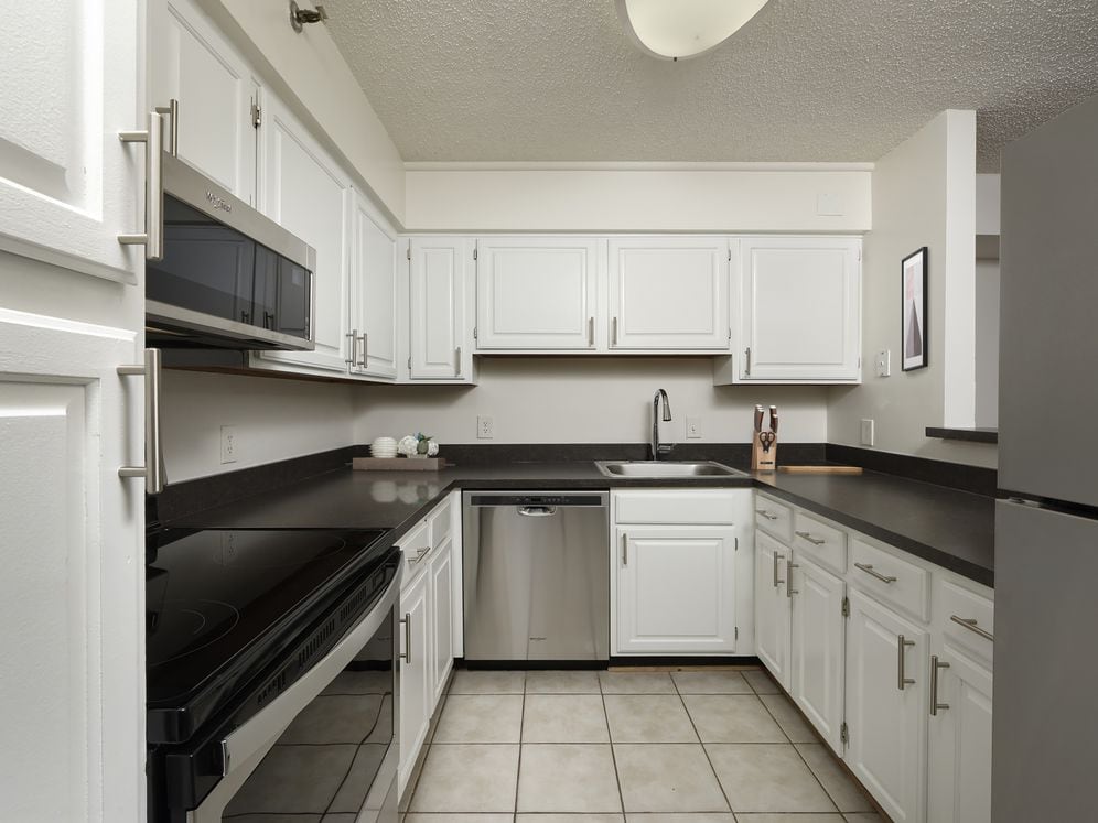 Finish Package II kitchen with white cabinetry, stainless steel appliances and tile flooring