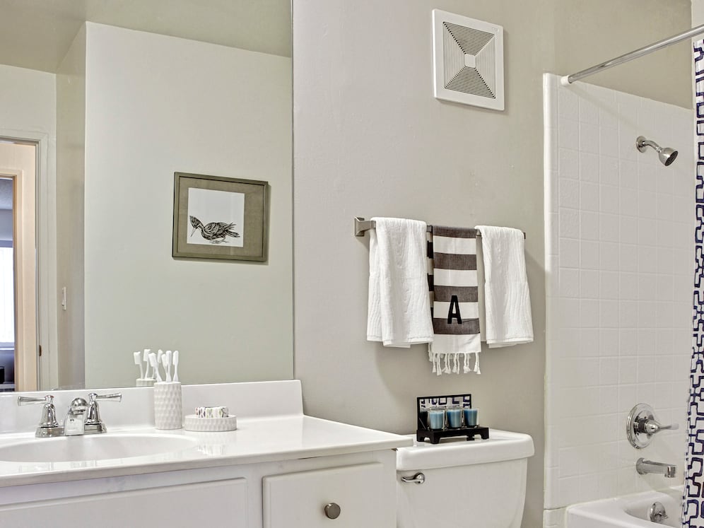 Classic Package I bath with white laminate countertop, white cabinetry, and hard surface flooring