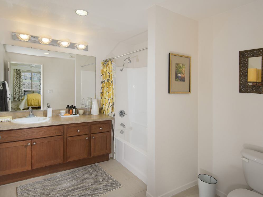 Classic Package I guest bath with maple cabinetry, beige speckled granite countertops, and tile flooring
