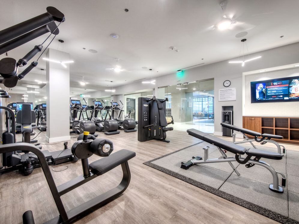 Fitness center with cardio equipment, strength equipment, and flat screen television