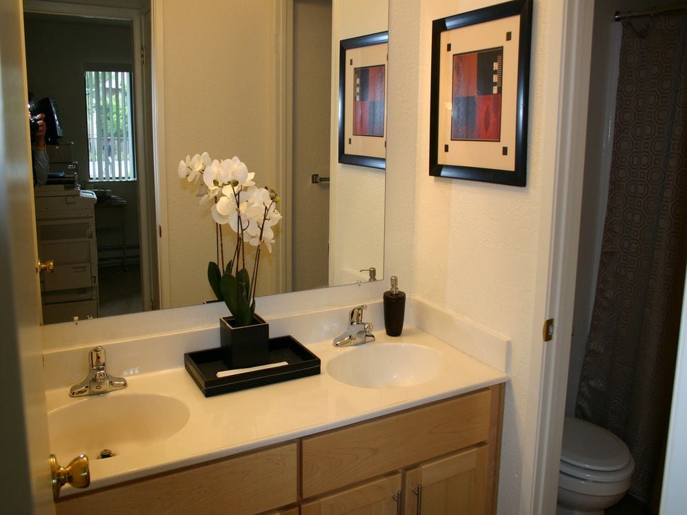 Bathroom with double vanity, oak cabinetry and white countertop