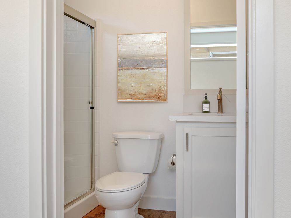 Freestanding Home bath with white quartz countertops, white cabinetry, and hard surface flooring