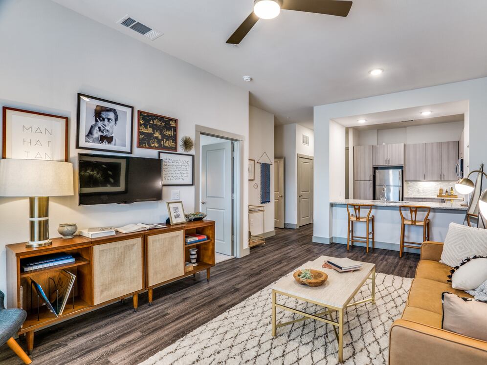 Gray finish package kitchen, living, and dining area with hard surface flooring and ceiling fan