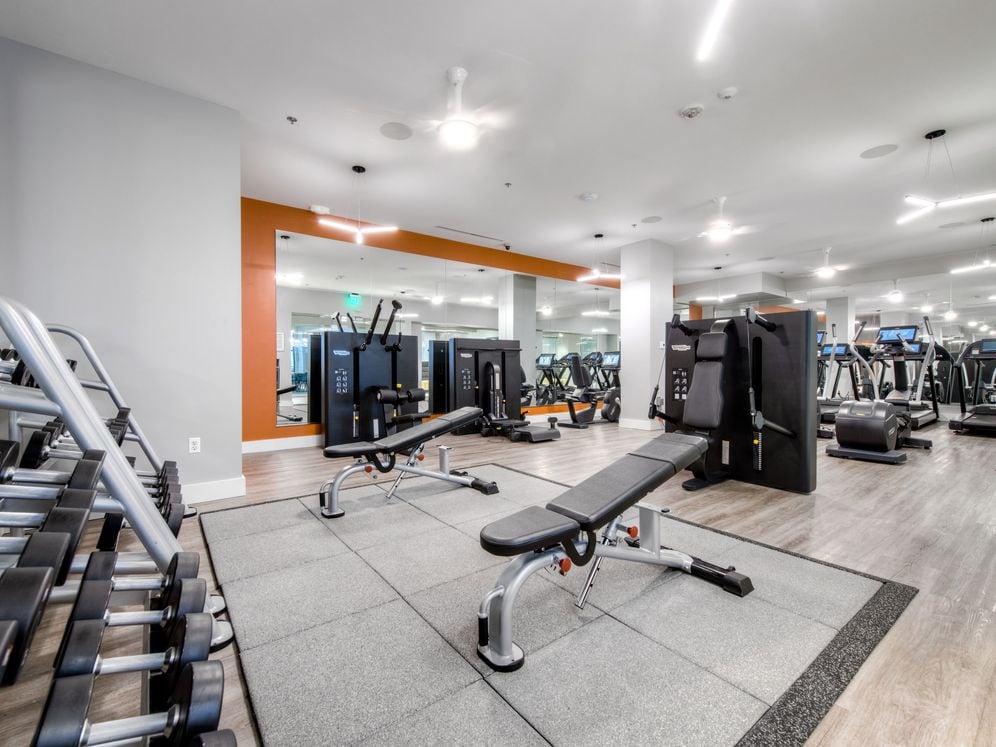 Fitness center with cardio equipment, strength equipment, and flat screen television